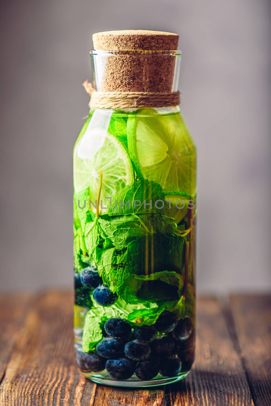 Bottle of Cleansing Water with Lime, Mint and Blueberry. Vertical Orientation.