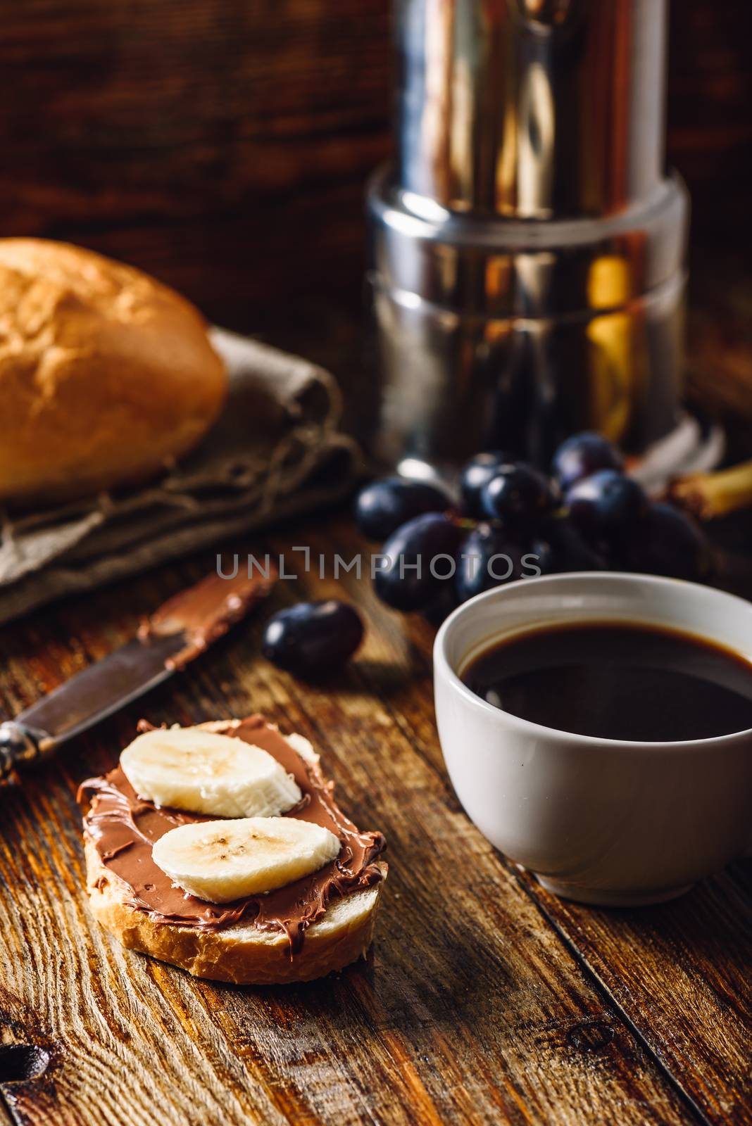 Breakfast with Banana Sandwich with Chocolate Spread, Coffee Cup and Grapes. Vertical Orientation.