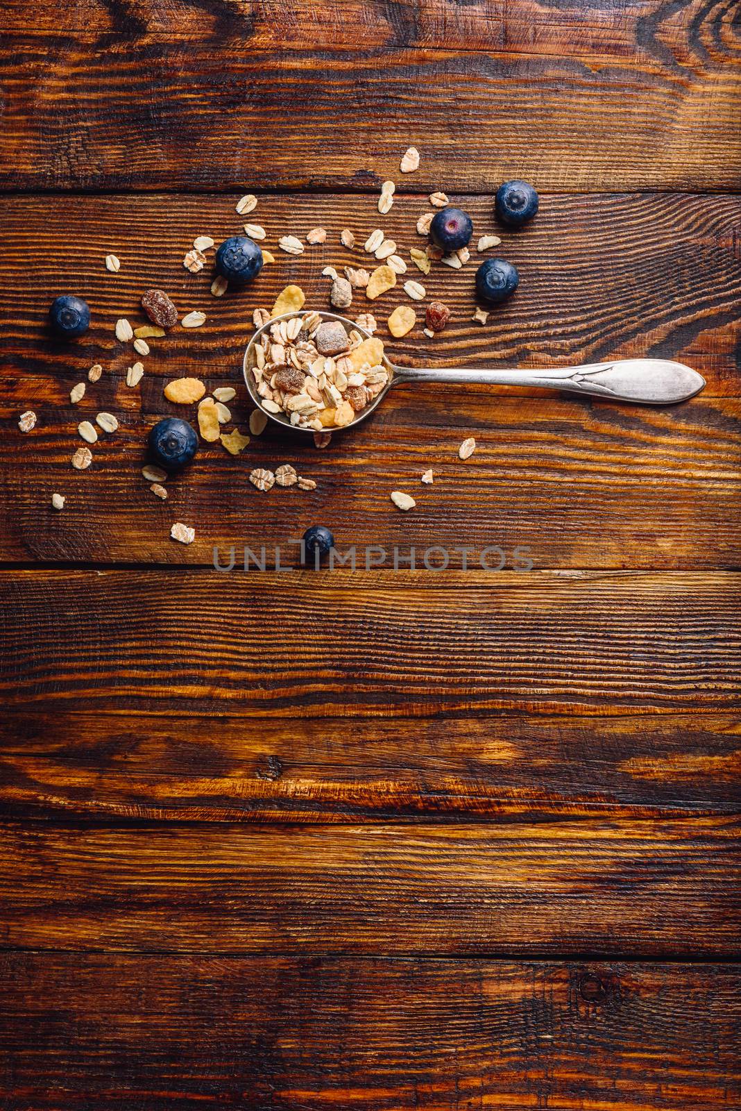 Spoonful of Granola and Blueberry on Wooden Table. View from Above. Vertical Orientation and Copy Space.