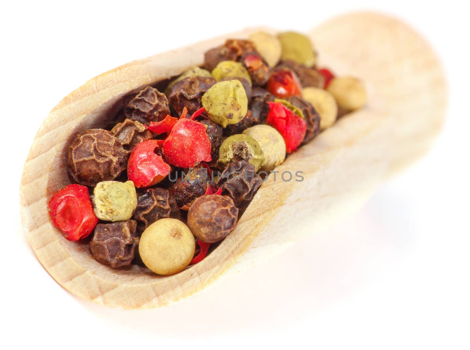 Color dryed Pepper on wooden spoon, isolated over White Background.
