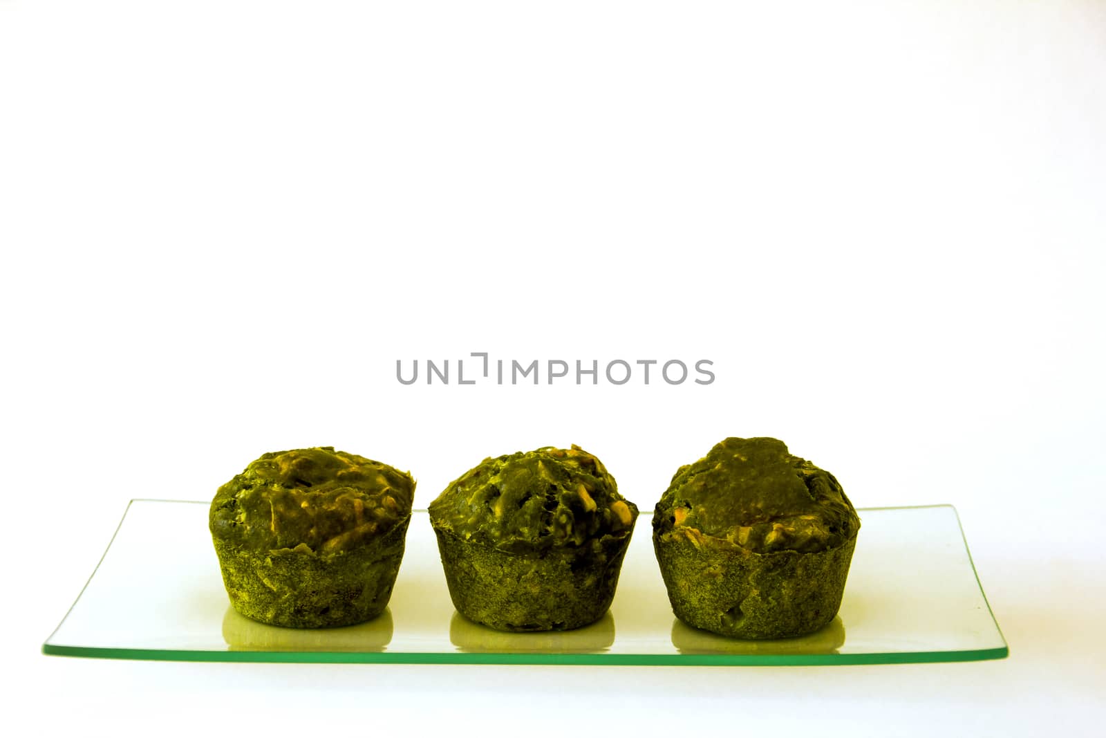 Three green cupcakes on a glass tray by Joanastockfoto