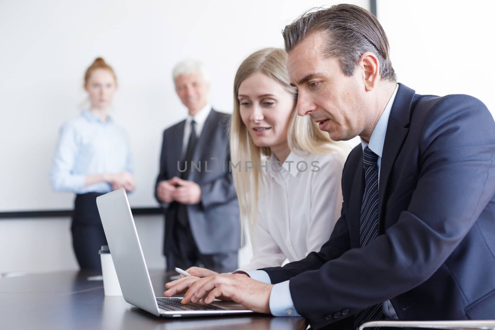 Business people working with laptop together in office