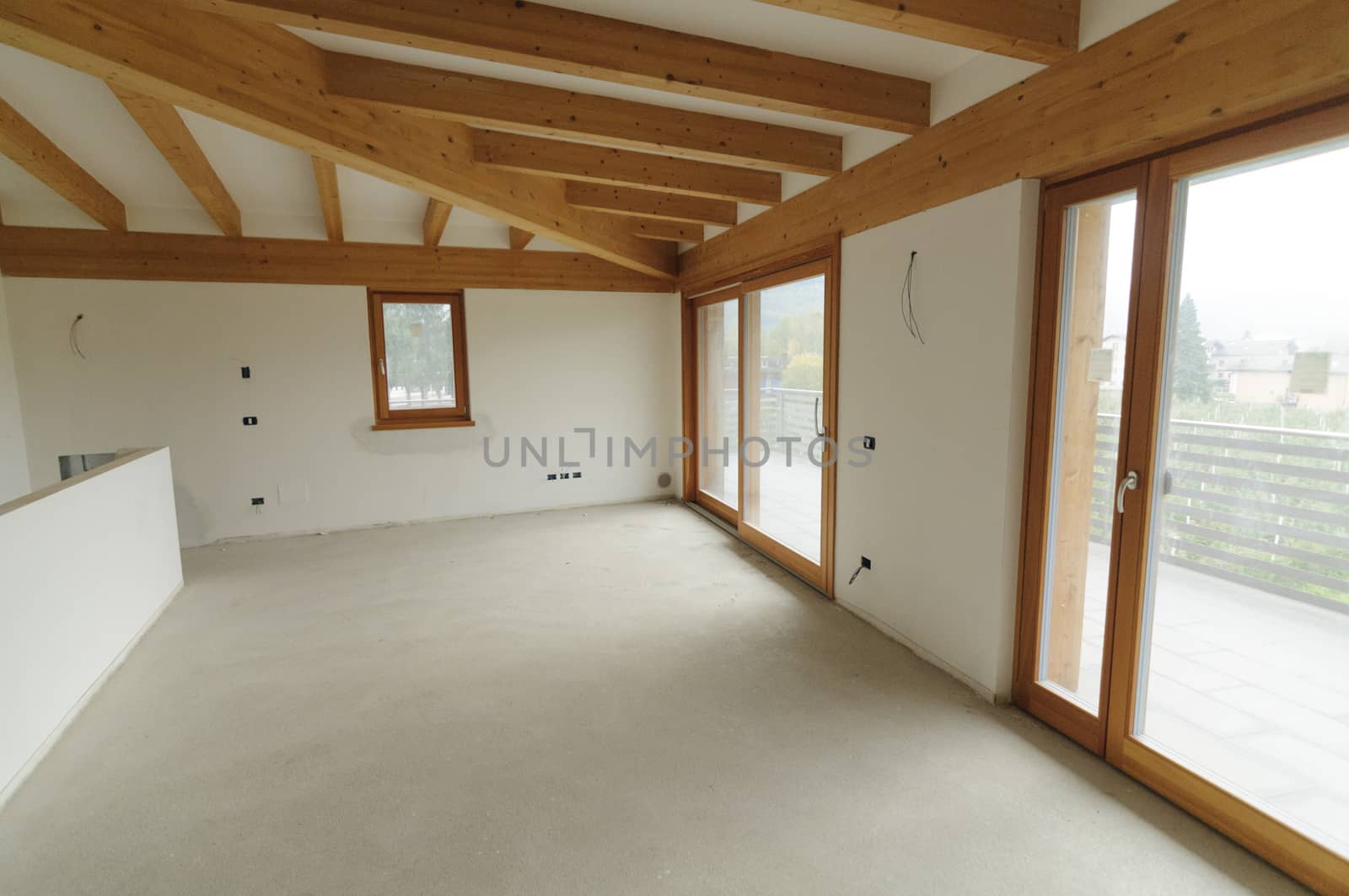 Building site or home renovation in progress: empty open space with large windows and exposed wooden beams