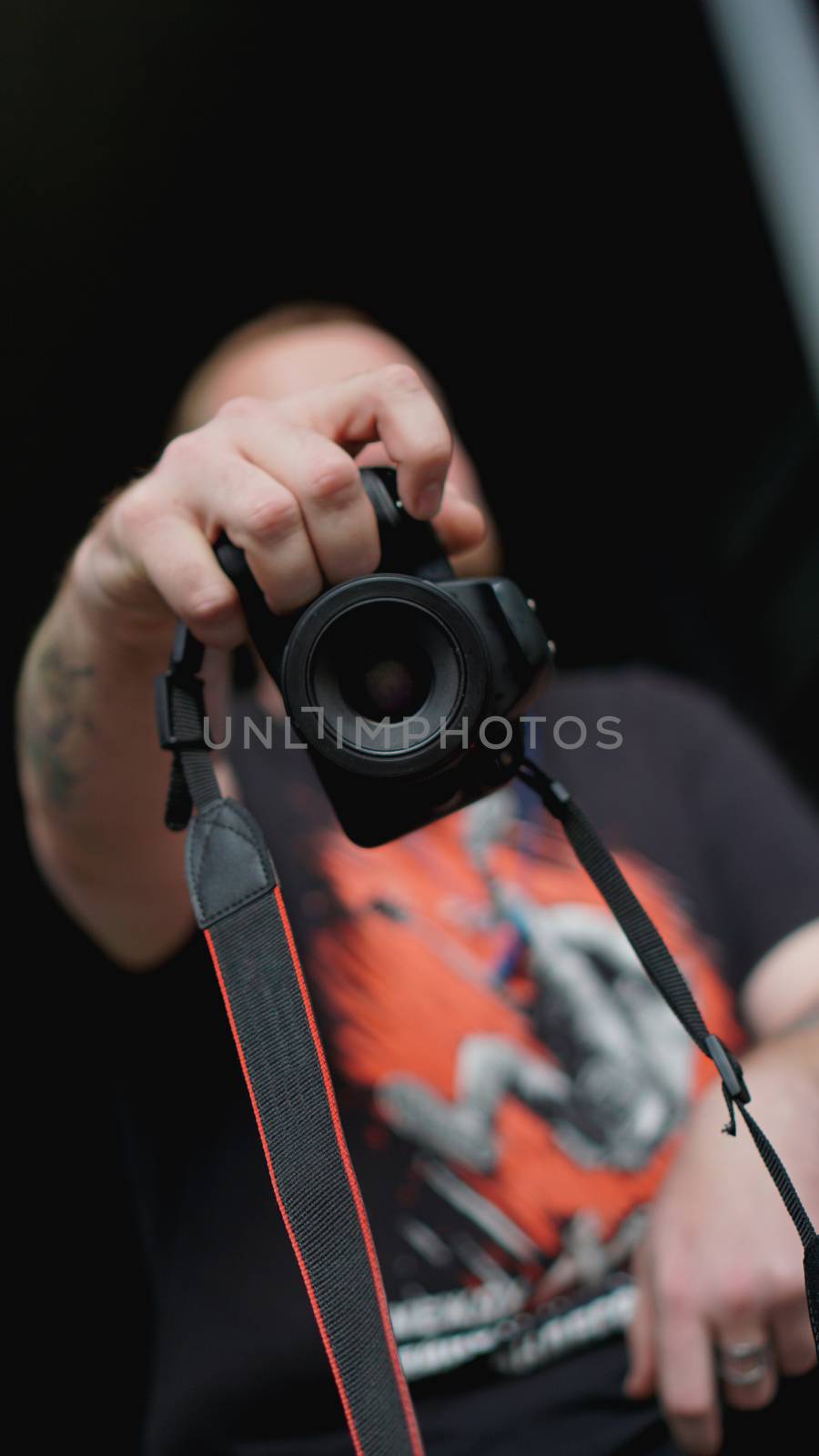 Young man photographer holds camera. Photographer concept.