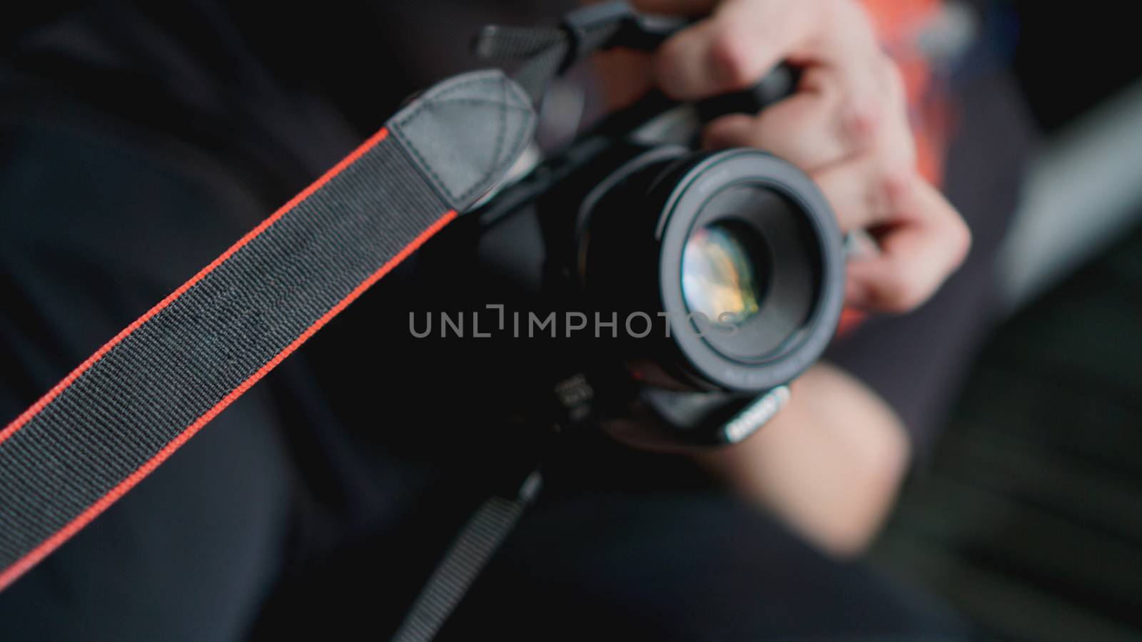 Young man photographer holds camera. Photographer concept. Blurred background for banner