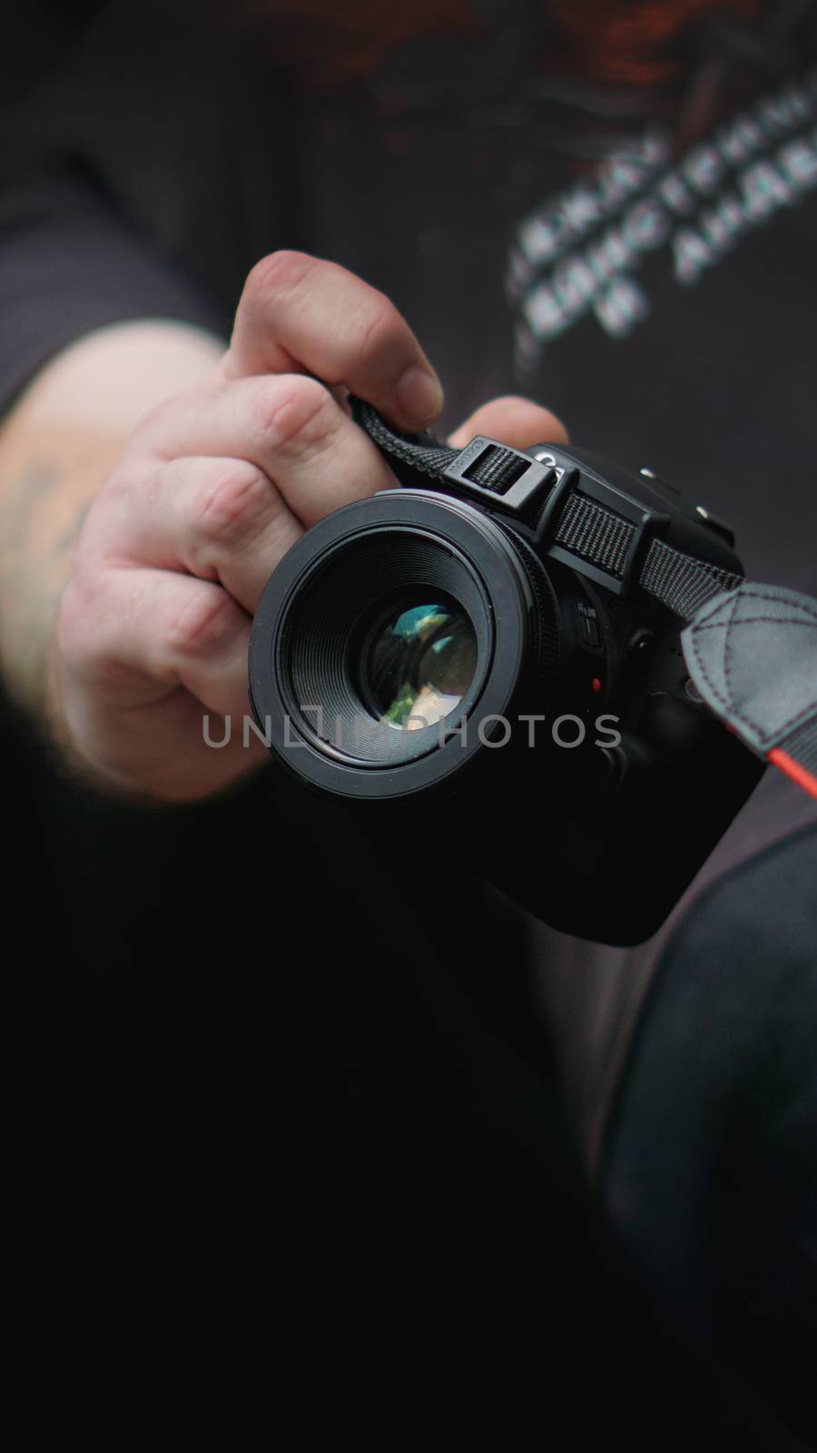 Young man photographer holds camera. Photographer concept.
