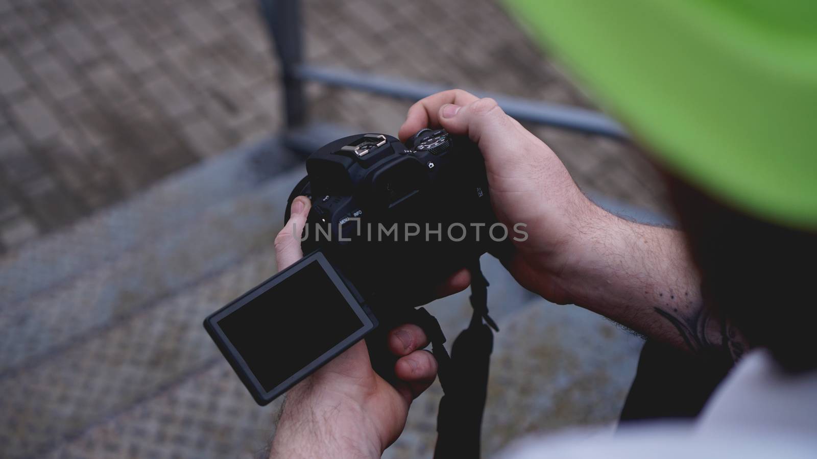 Young man photographer holds camera. Photographer concept. Swivel camera screen. camera mockup