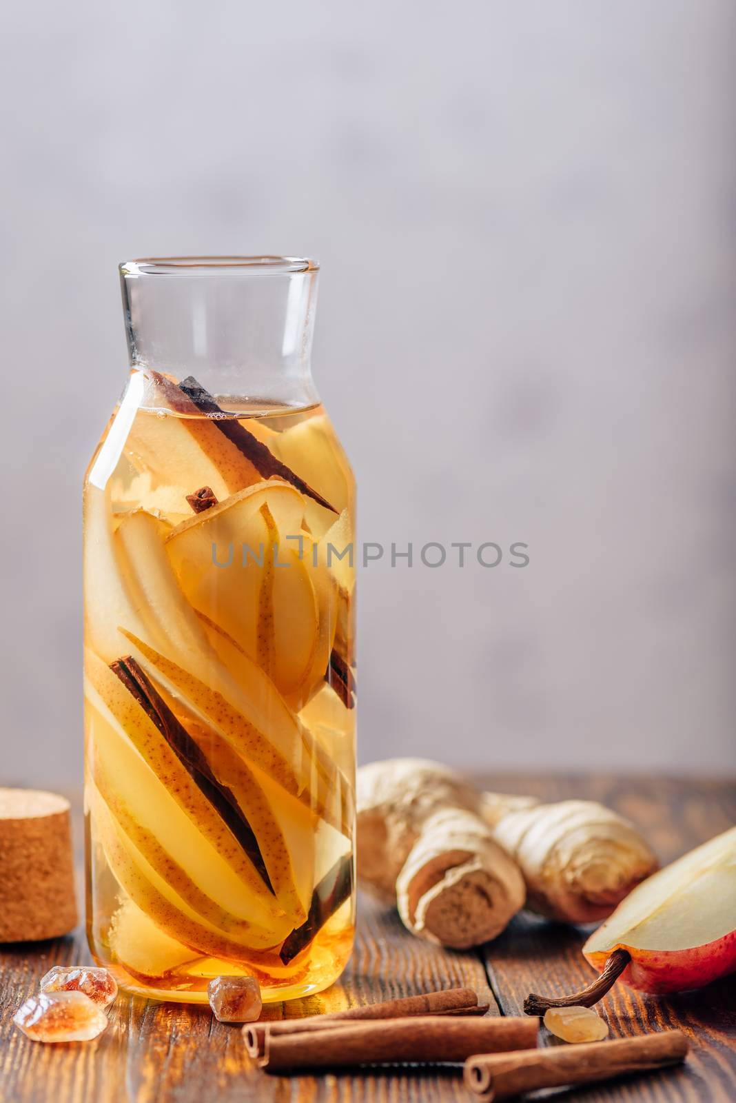 Water Flavored with Pear, Ginger Root and Cinnamon Stick. Some Ingredients on Table. Vertical Orientation and Copy Space.