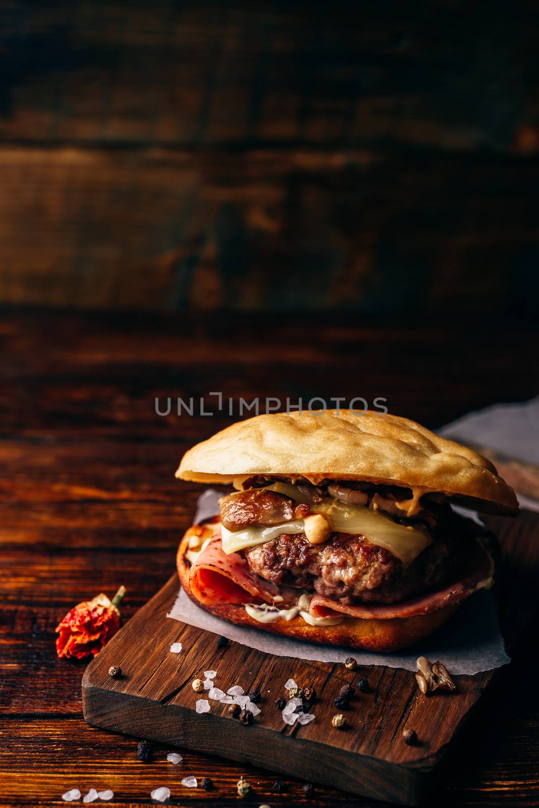 Cheeseburger with Beef Patty, Wisconsin Swiss Cheese, Ham, Sauteed Mushrooms, Dijon Mustard, Mayonnaise and Potato Roll. Vertical Orientation and Copy Space.