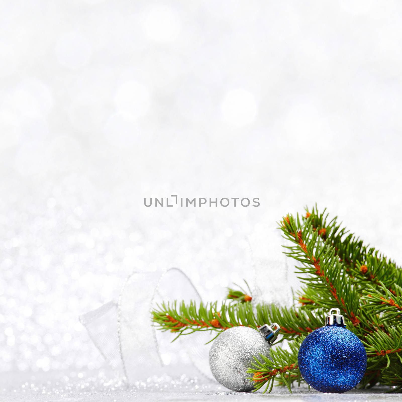 Christmas fir tree branch and decoration on silver glitter background