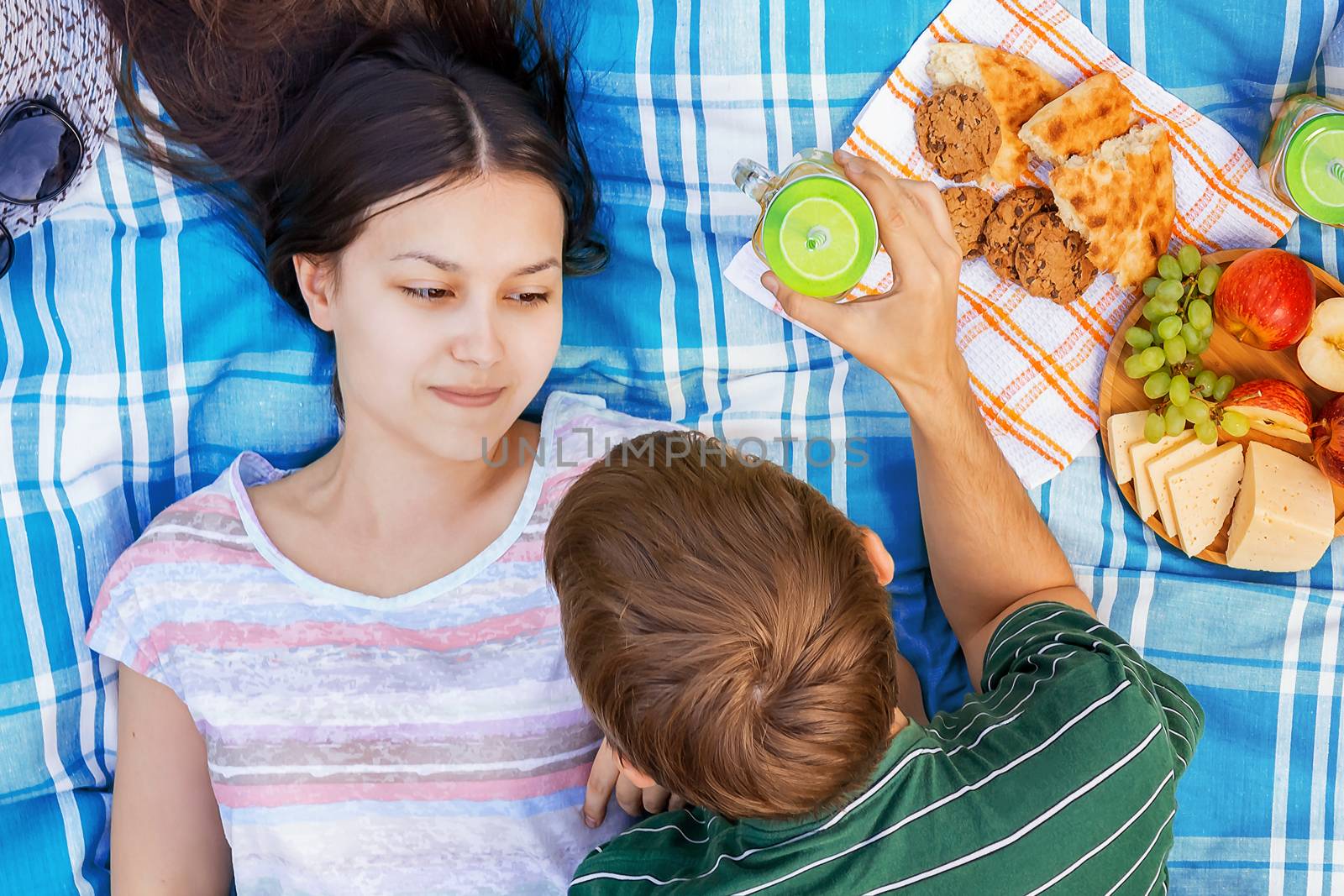 Young loving couple resting on a picnic on a summer day by galsand