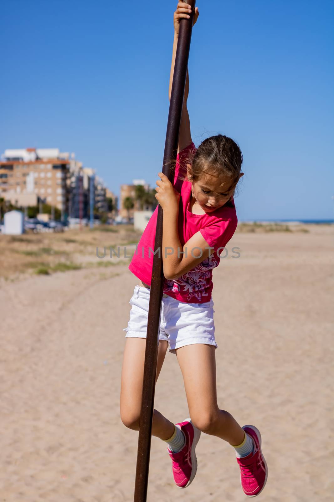 Little girl playing in a playground on the beach