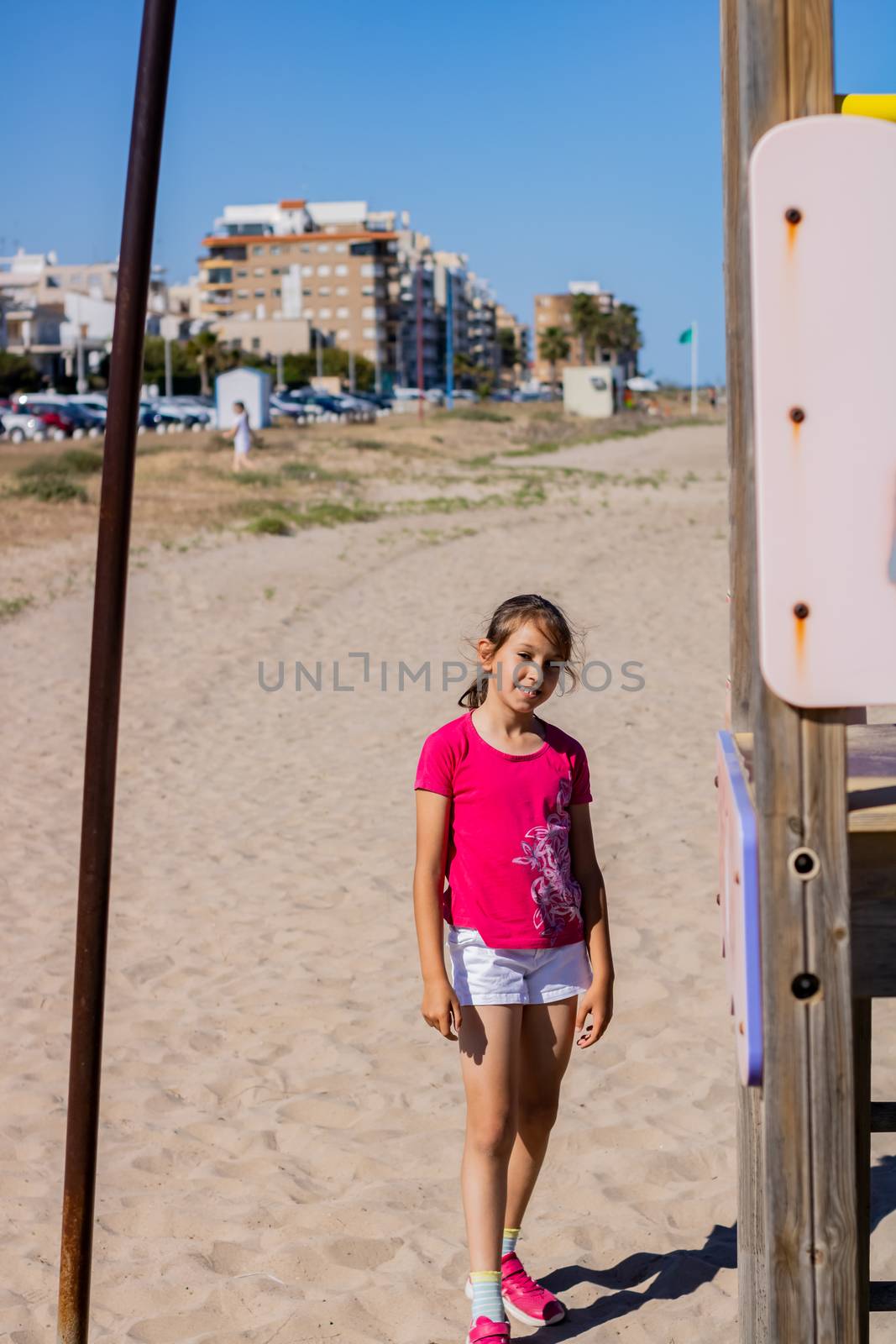 Little girl playing in a playground on the beach