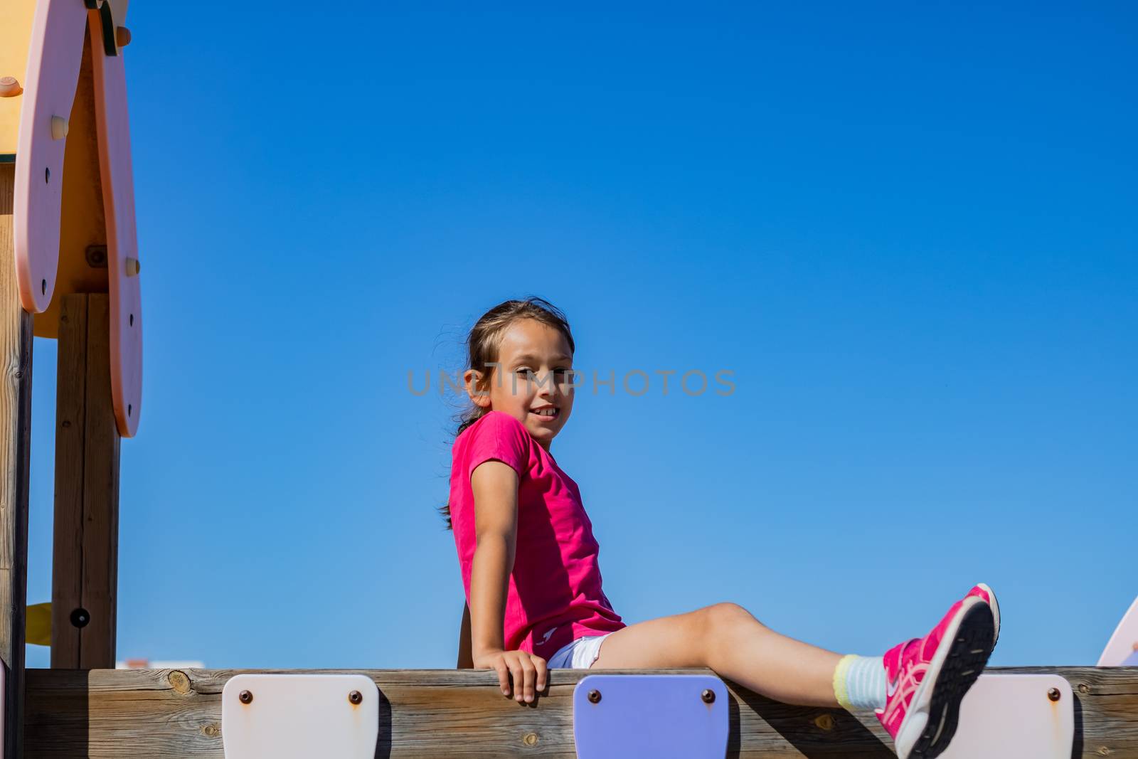Little girl playing in a playground on the beach