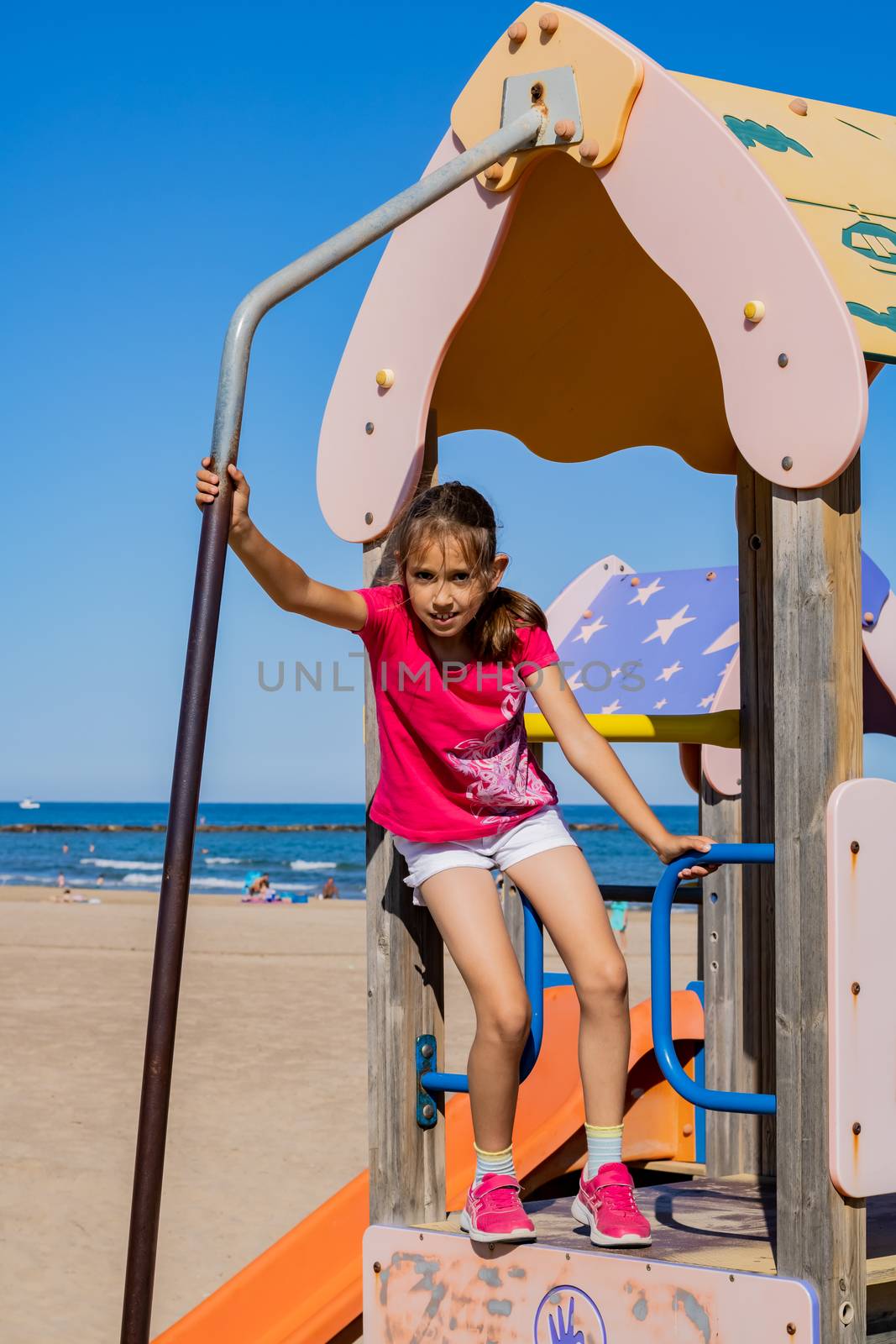 Little girl playing in a playground on the beach