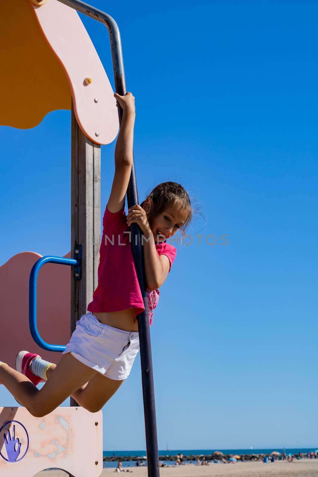 Little girl playing in a playground on the beach