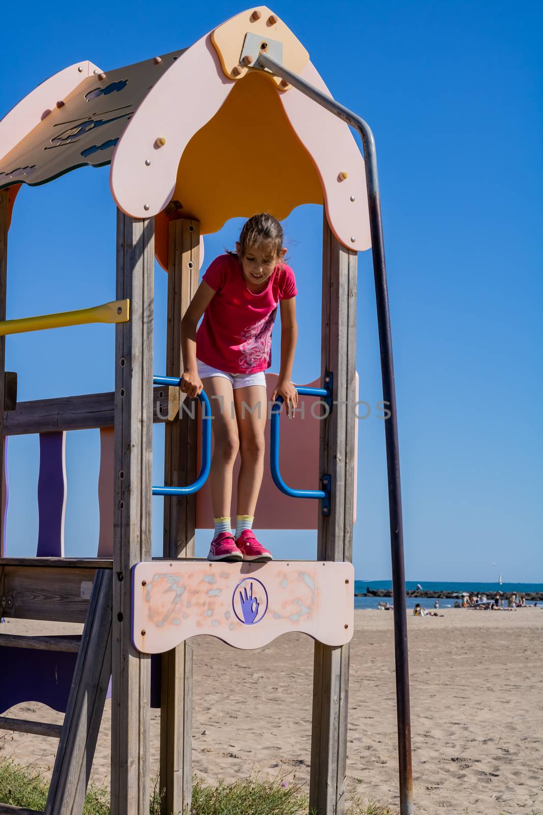 Little girl playing in a playground on the beach