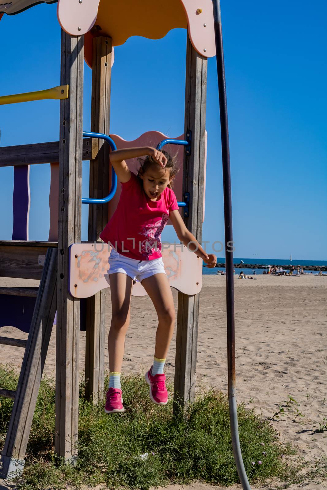 Little girl playing in a playground on the beach