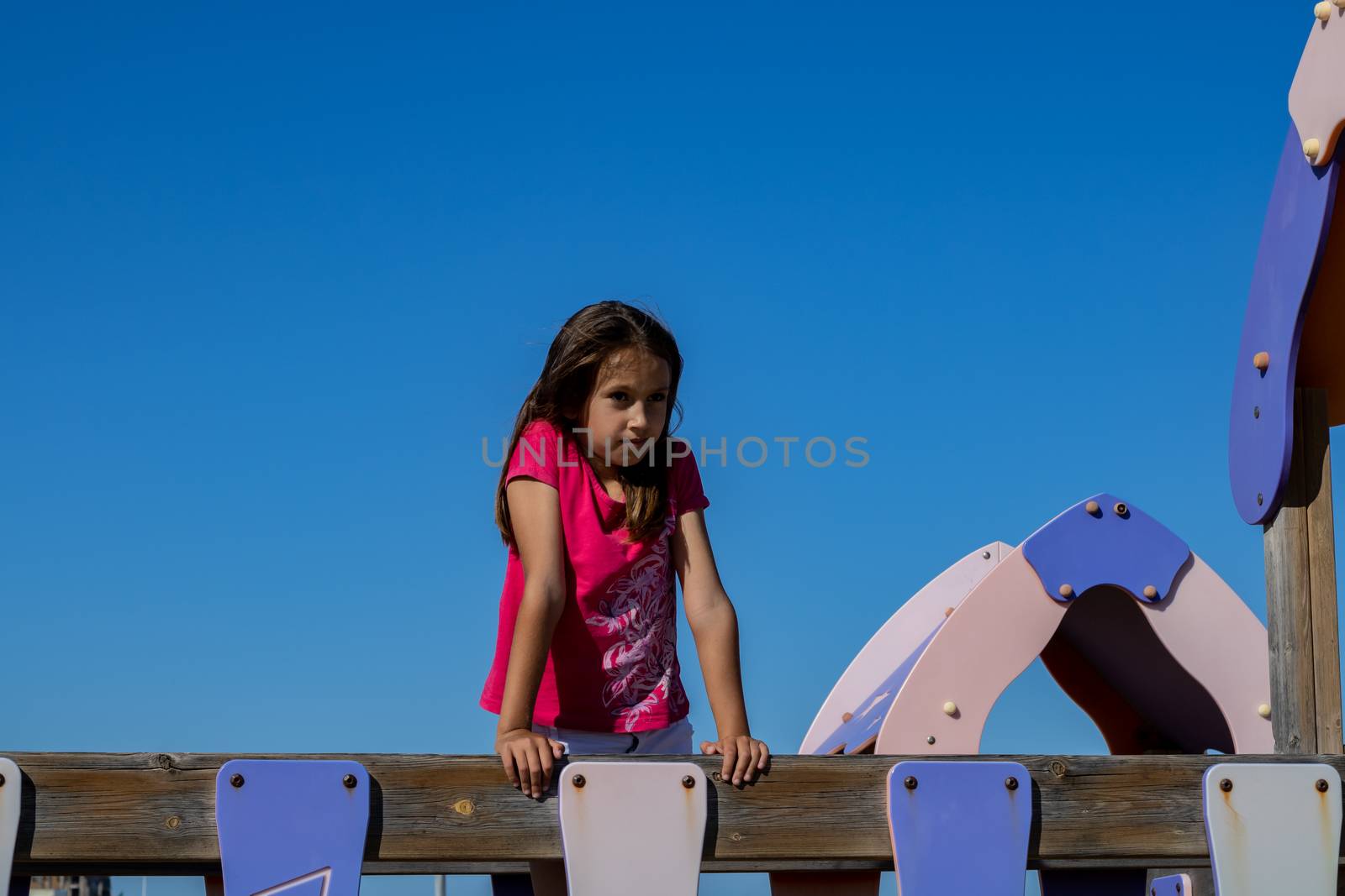 Little girl playing in a playground on the beach