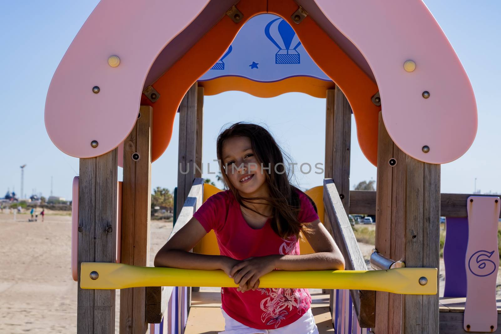 Little girl playing in a playground on the beach