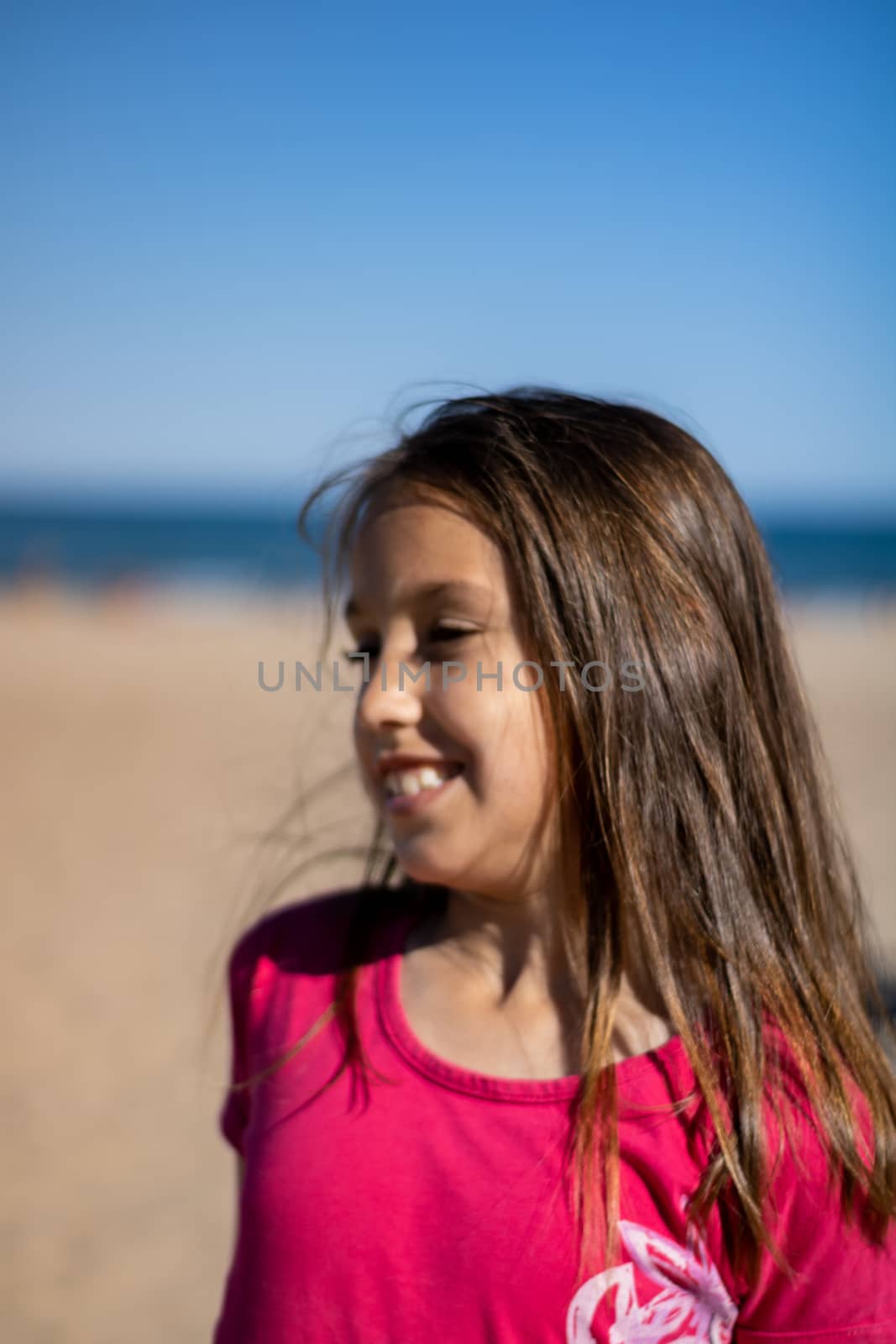 Little girl posing on the beach with the Mediterranean Sea in the background