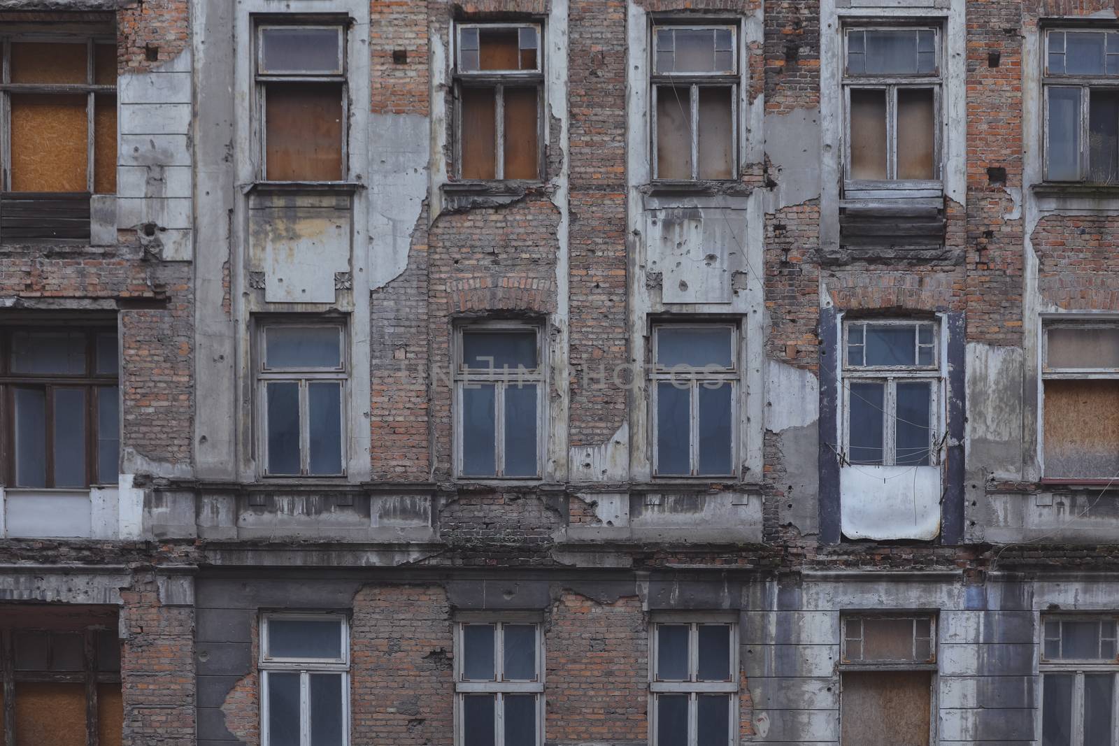 A front of the building in the center of Warsaw that is partially destroyed by nature and climate. Grunge look makes it feel depressed. Matted colors to make it comfortable to be used as wallpaper on electronic devices