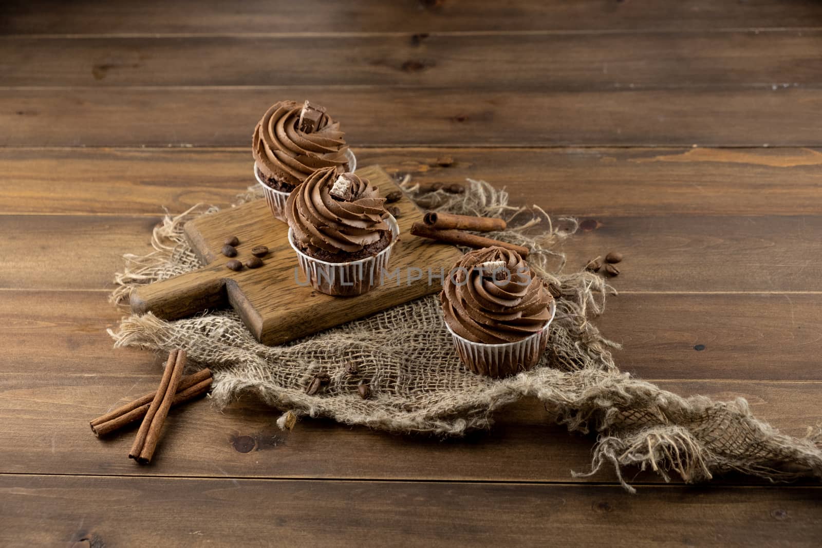 brown cupcakes with cocoa cream, cinnamon and coffee