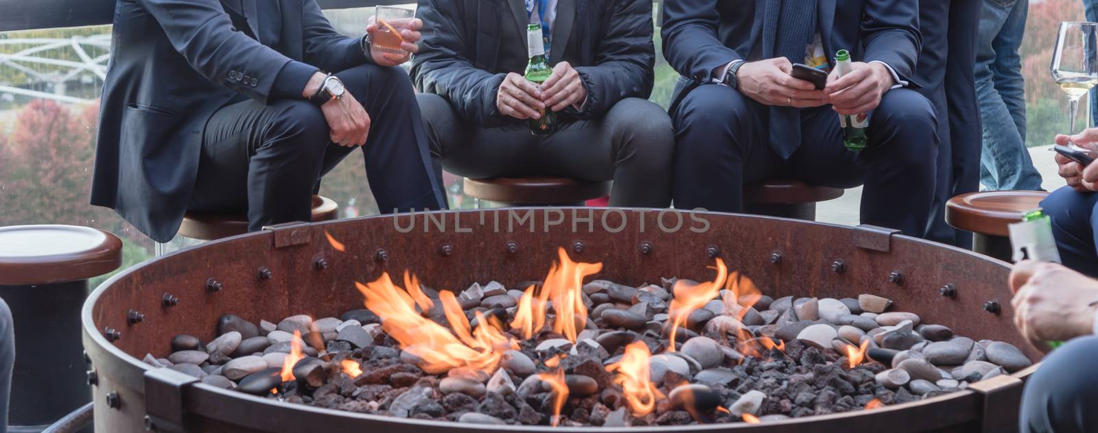 Panoramic view businesspeople hangout near patio fire pit at rooftop bar in Chicago by trongnguyen