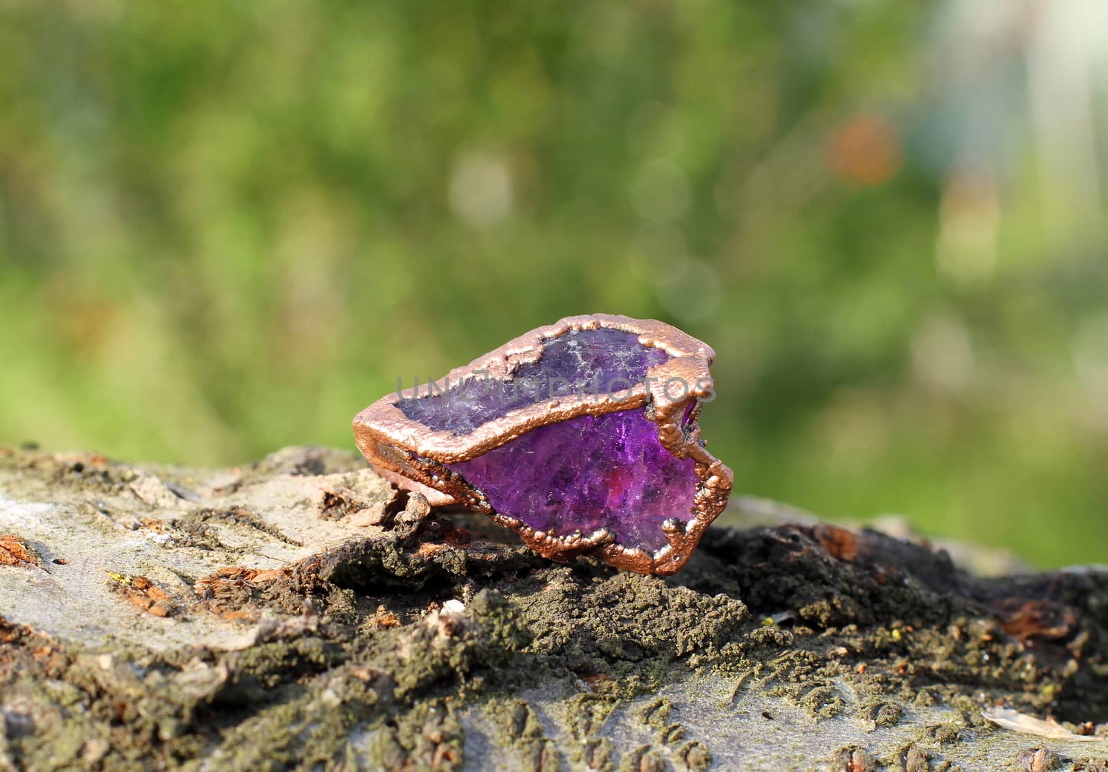 the Hand made copper ring with amethyst on the wooden background