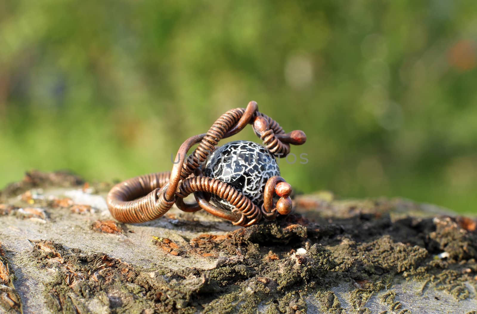 the Hand made copper ring with semiprecious stone on the wooden background