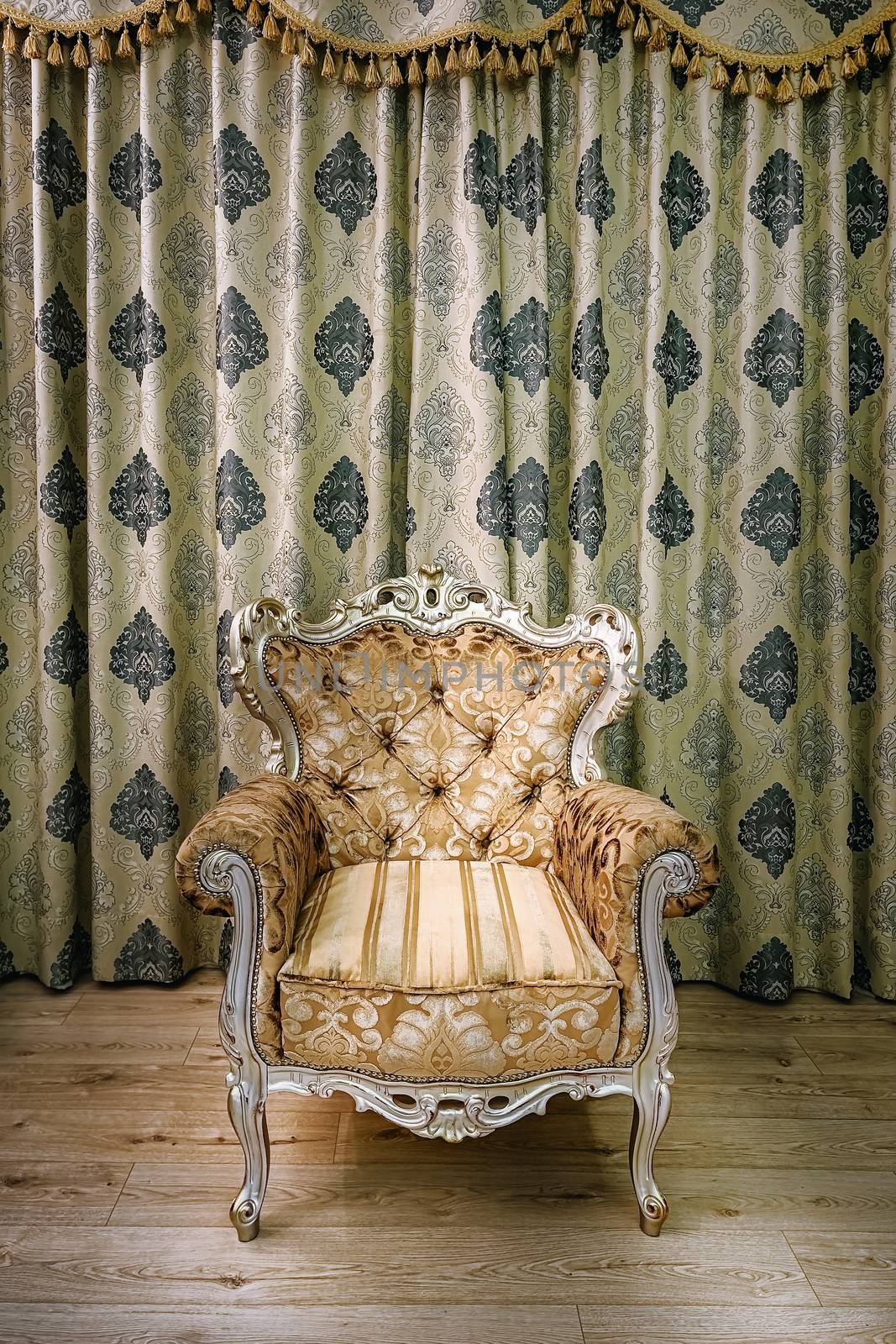 Old armchair in the room near the curtained window