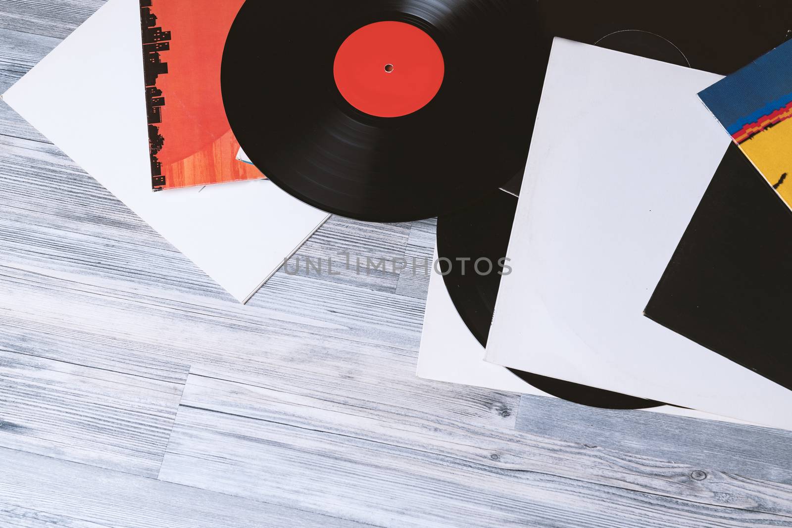 Black vinyl record and covers album on the background of their gray wooden boards.Vintage style with copy space.