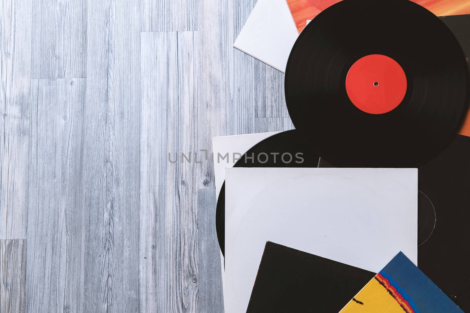 Black vinyl record and covers album on the background of their gray wooden boards.Vintage style with copy space.