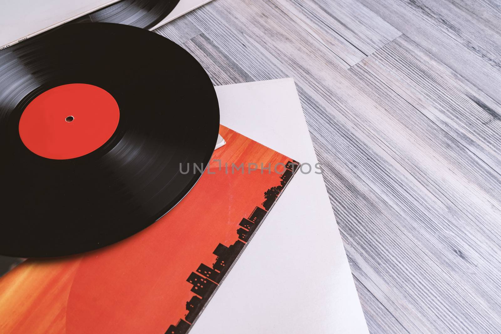 Black vinyl record and covers album on the background of their gray wooden boards.Vintage style with copy space.