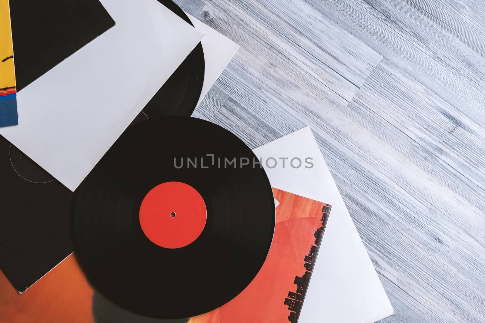 Black vinyl record and covers album on the background of their gray wooden boards.Vintage style with copy space.