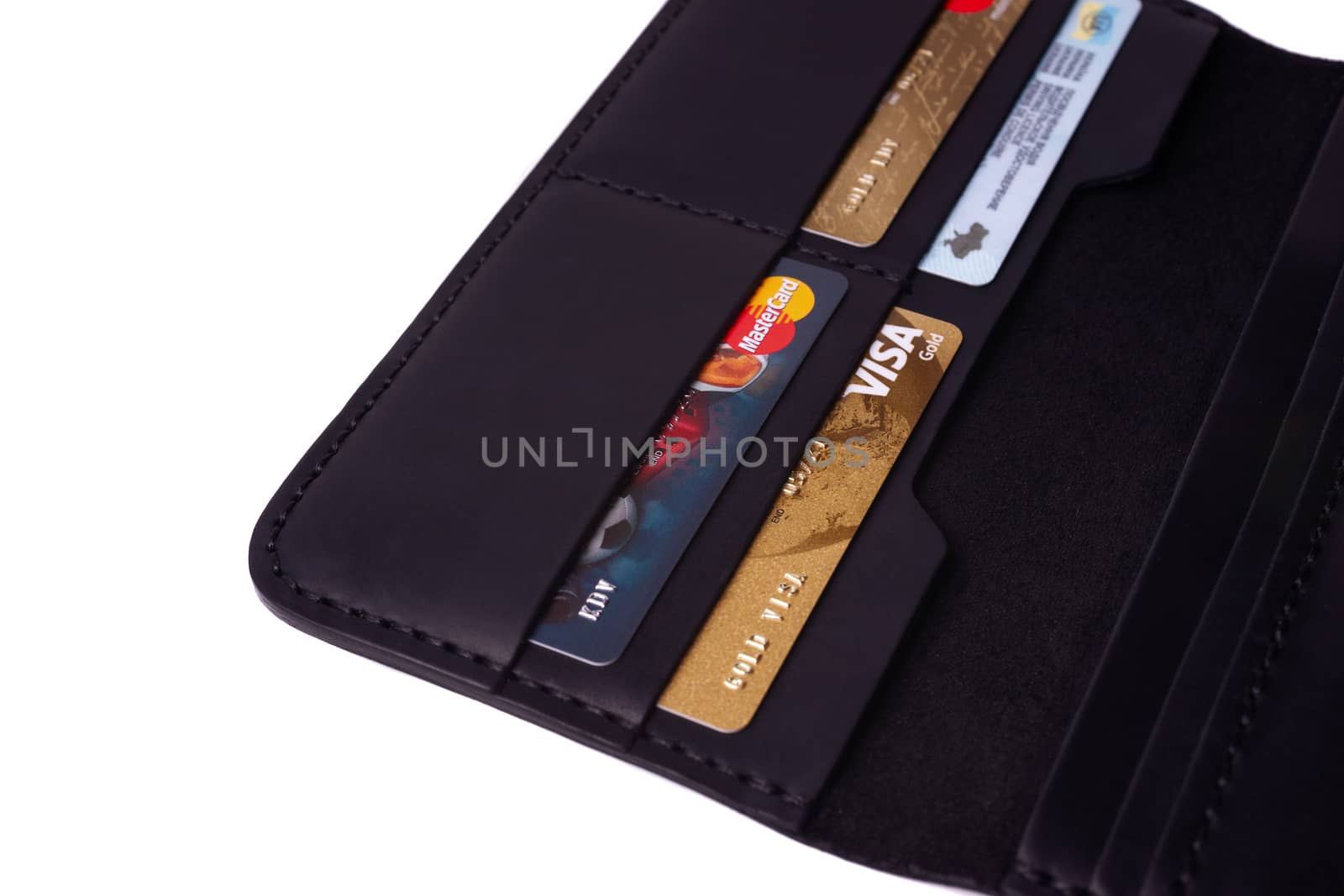 24.01.2019 Ukraine, Kyiv. A part of handmade black leather wallet isolated on white background closeup. A lot of plastic cards in purse pockets. Editorial use only.