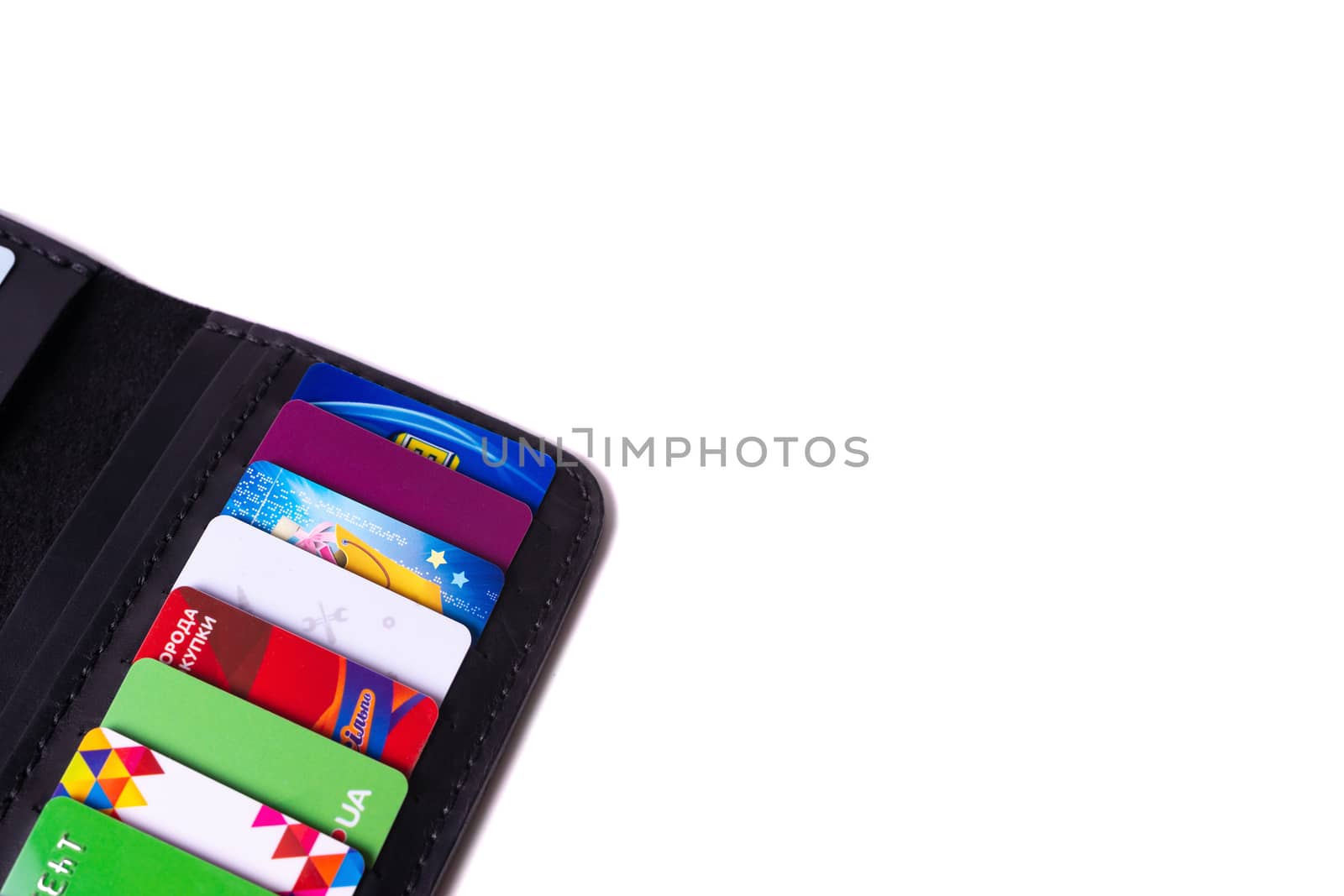 24.01.2019 Ukraine, Kyiv. A part of handmade black leather wallet isolated on white background closeup. A lot of plastic cards in purse pockets. Editorial use only.