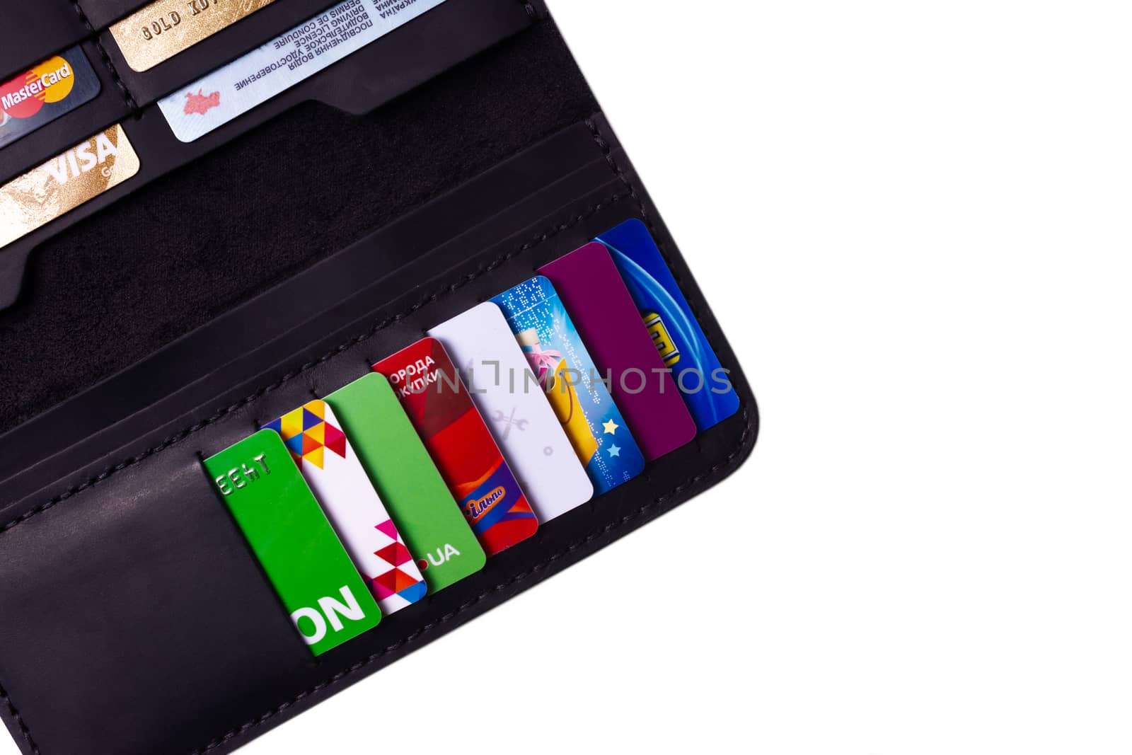 24.01.2019 Ukraine, Kyiv. A part of handmade black leather wallet isolated on white background closeup. A lot of plastic cards in purse pockets. Editorial use only.