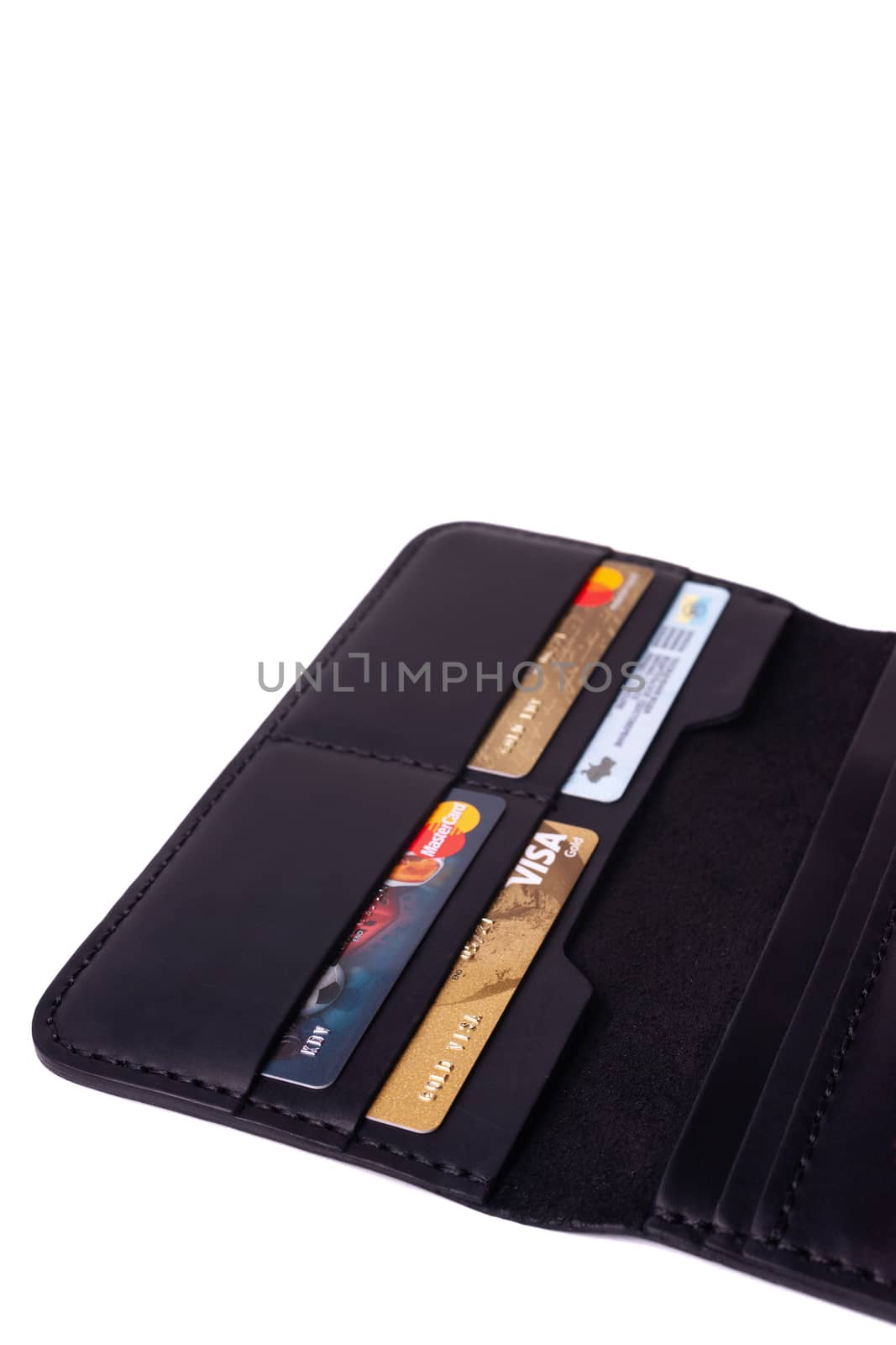 24.01.2019 Ukraine, Kyiv. A part of handmade black leather wallet isolated on white background closeup. A lot of plastic cards in purse pockets. Editorial use only.