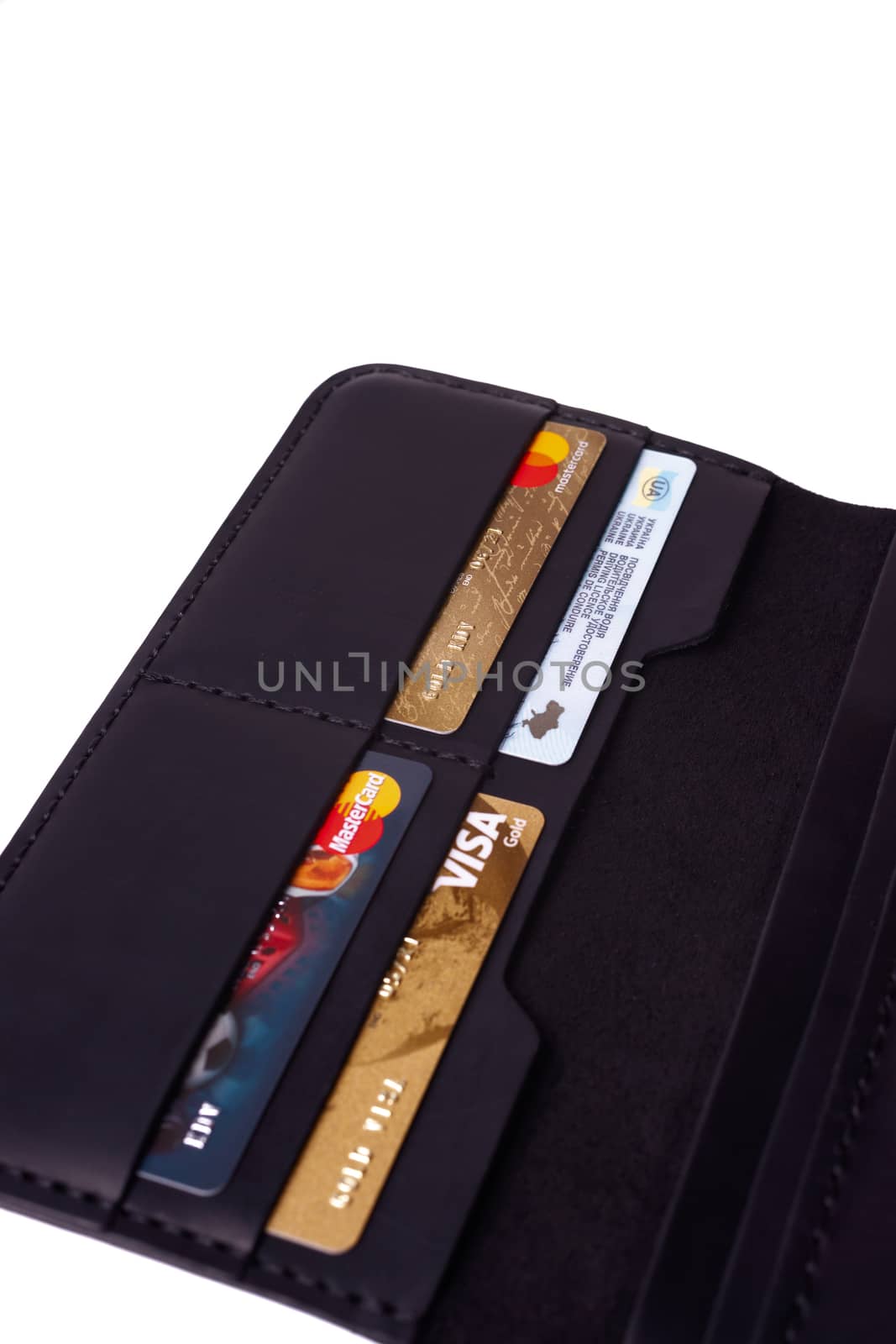 24.01.2019 Ukraine, Kyiv. A part of handmade black leather wallet isolated on white background closeup. A lot of plastic cards in purse pockets. Editorial use only.