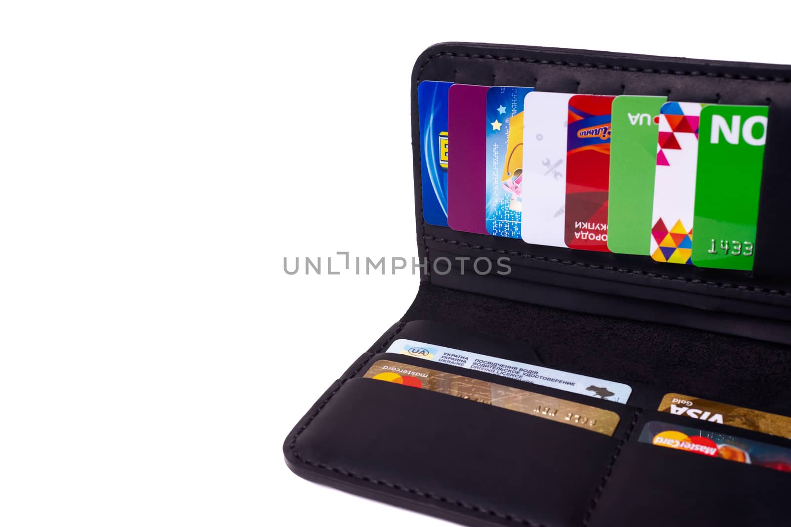 24.01.2019 Ukraine, Kyiv. A part of handmade black leather wallet isolated on white background closeup. A lot of plastic cards in purse pockets. Editorial use only.