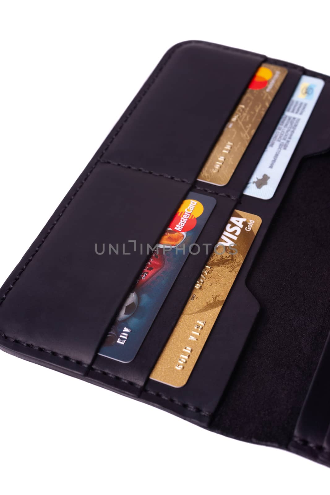 24.01.2019 Ukraine, Kyiv. A part of handmade black leather wallet isolated on white background closeup. A lot of plastic cards in purse pockets. Editorial use only.