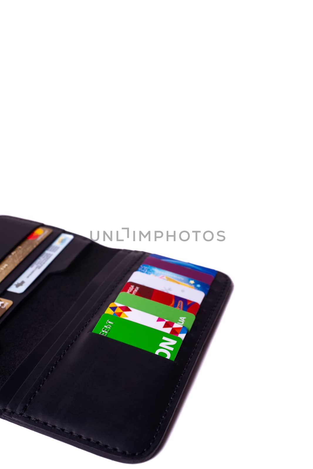 24.01.2019 Ukraine, Kyiv. A part of handmade black leather wallet isolated on white background closeup. A lot of plastic cards in purse pockets. Editorial use only.