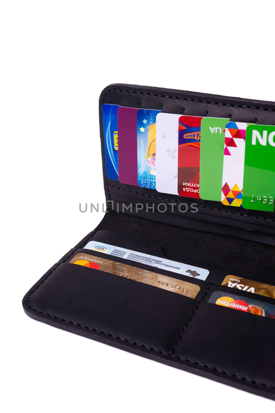 24.01.2019 Ukraine, Kyiv. A part of handmade black leather wallet isolated on white background closeup. A lot of plastic cards in purse pockets. Editorial use only.