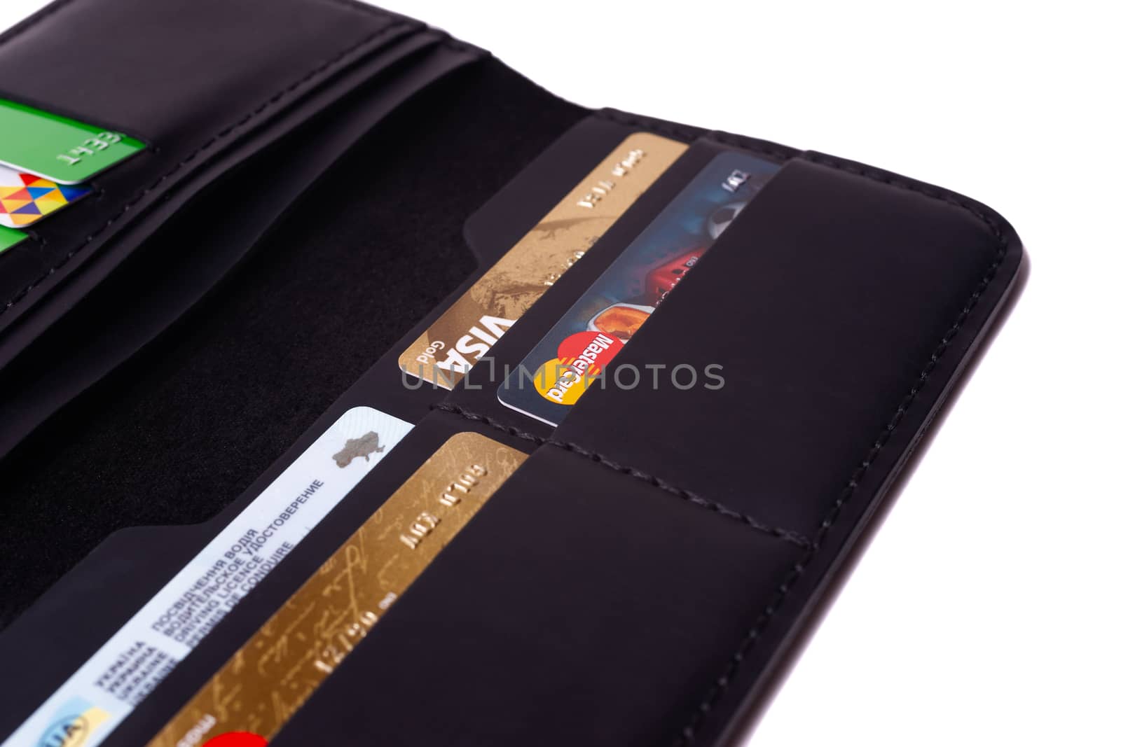 24.01.2019 Ukraine, Kyiv. A part of handmade black leather wallet isolated on white background closeup. A lot of plastic cards in purse pockets. Editorial use only.