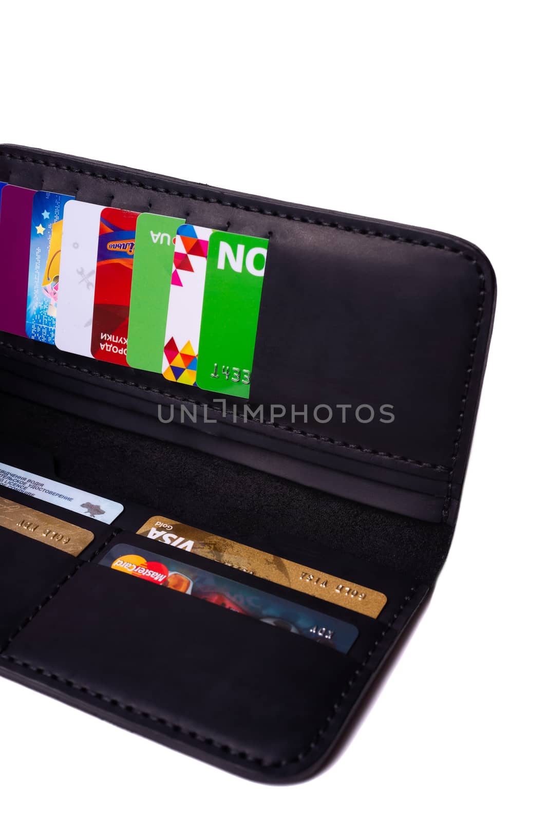 24.01.2019 Ukraine, Kyiv. A part of handmade black leather wallet isolated on white background closeup. A lot of plastic cards in purse pockets. Editorial use only.