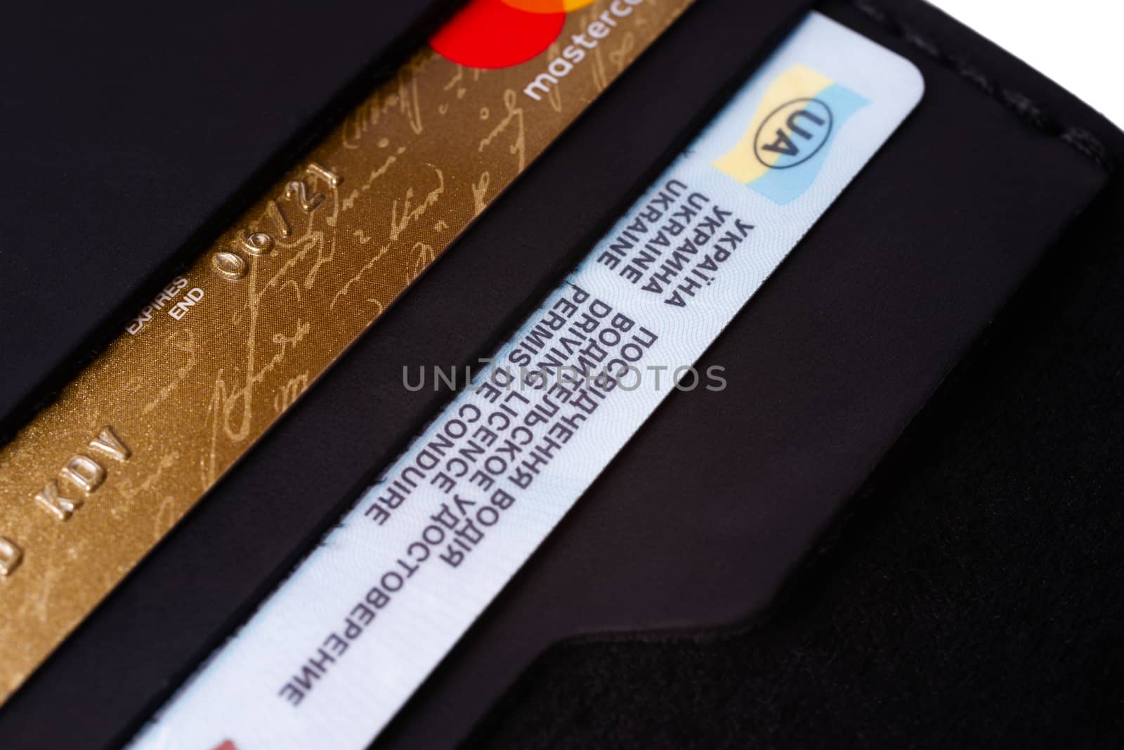 24.01.2019 Ukraine, Kyiv. A part of handmade black leather wallet isolated on white background closeup. A lot of plastic cards in purse pockets. Editorial use only.