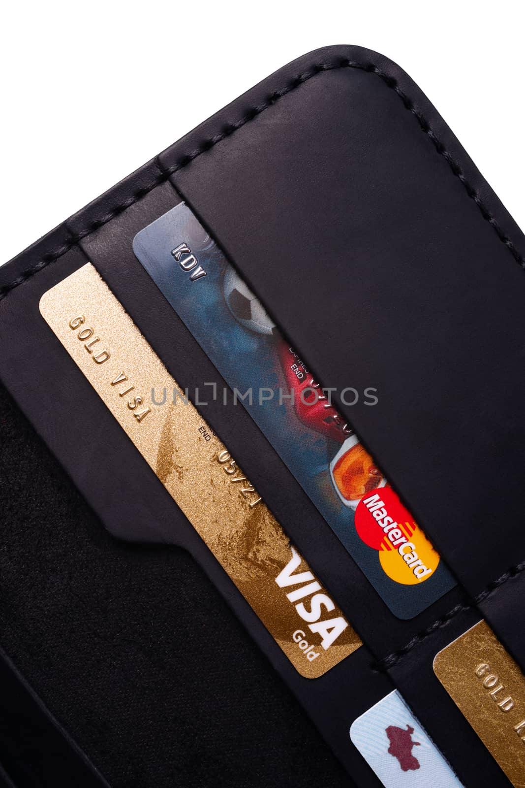 24.01.2019 Ukraine, Kyiv. A part of handmade black leather wallet isolated on white background closeup. A lot of plastic cards in purse pockets. Editorial use only.