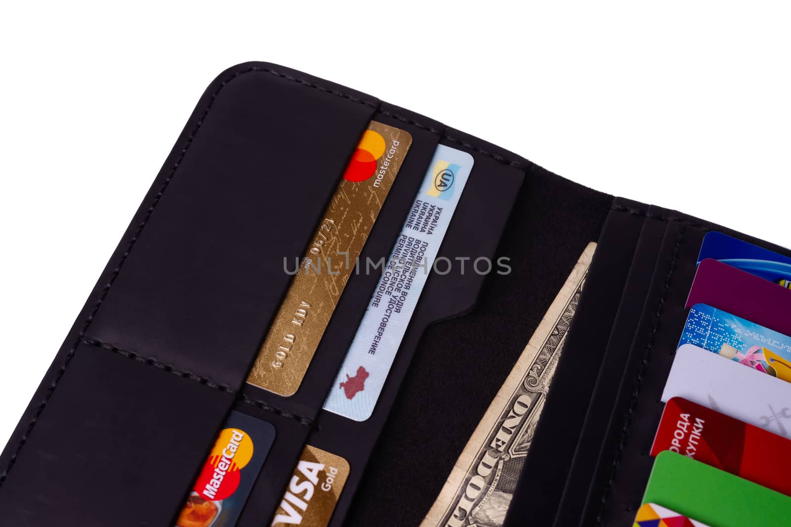 24.01.2019 Ukraine, Kyiv. A part of handmade black leather wallet isolated on white background closeup. A lot of plastic cards in purse pockets. Editorial use only.