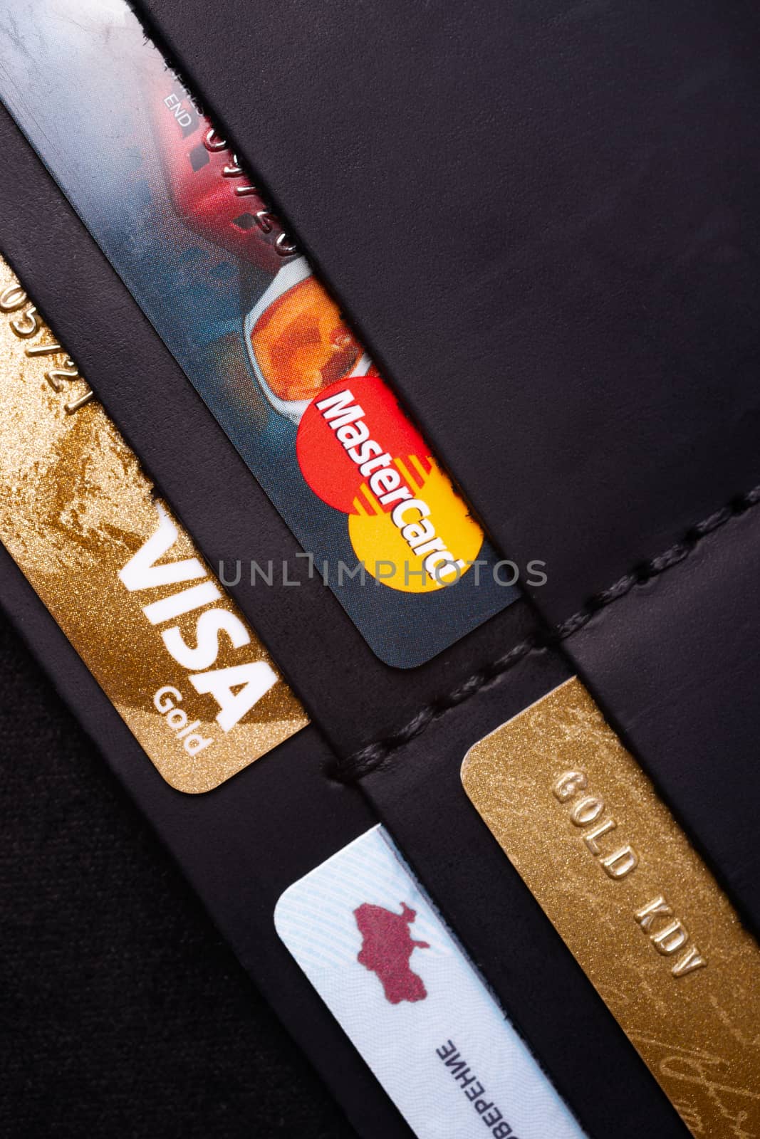 24.01.2019 Ukraine, Kyiv. A part of handmade black leather wallet isolated on white background closeup. A lot of plastic cards in purse pockets. Editorial use only.